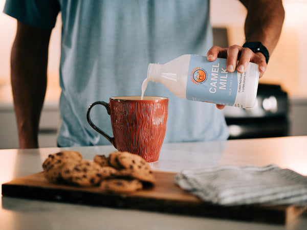 Man pouring camel milk into his coffee