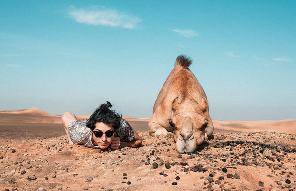 A man and a camel in the desert getting ready to enjoy camel milk from Camel Culture 