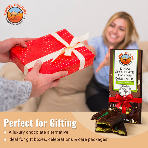 Person handing a red gift box with a woman receiving it, alongside Camel Culture Dubai chocolate packaging.