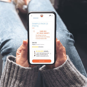 Person holding a smartphone displaying an app with product details.